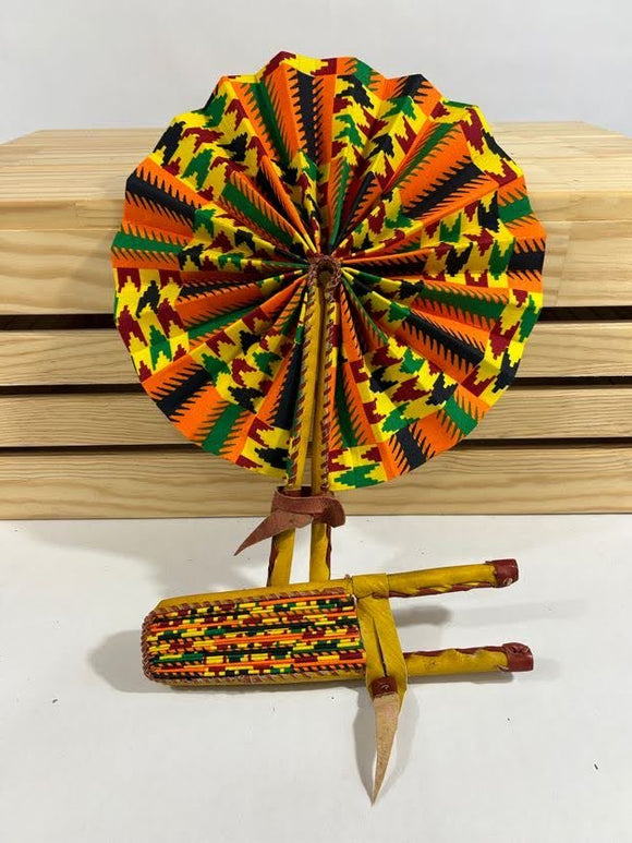 Elevate your style with our foldable handmade African fan from Ghana. Crafted with vibrant African wax print fabric and goat leather, this compact accessory is perfect for any occasion. Carry a piece of Ghana with you in your purse or bag. [Yellow Leather, Black, Orange, & Green Fabric] Embrace the artistry of Ghanaian craftsmanship. #Handmade #AfricanFashion #GhanaCrafts #WomenOwned #ShopWithPurpose #BusankamWolaFoundation