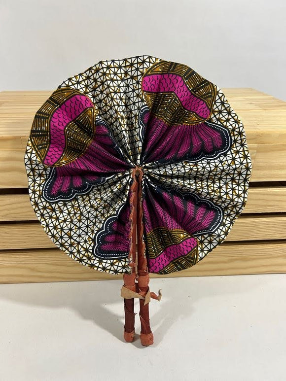 Elevate your style with our foldable handmade African fan from Ghana. Crafted with vibrant African wax print fabric and goat leather, this compact accessory is perfect for any occasion. Carry a piece of Ghana with you in your purse or bag. [Brown Leather, Purple & Brown Fabric] Embrace the artistry of Ghanaian craftsmanship. #Handmade #AfricanFashion #GhanaCrafts #WomenOwned #ShopWithPurpose #BusankamWolaFoundation